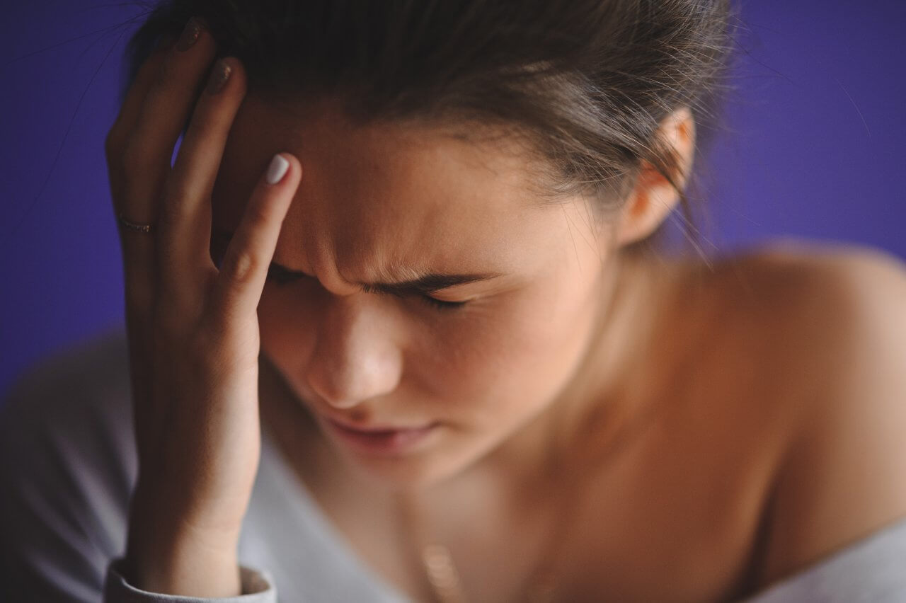 Teen woman with headache holding her hand to head - Daniels ...